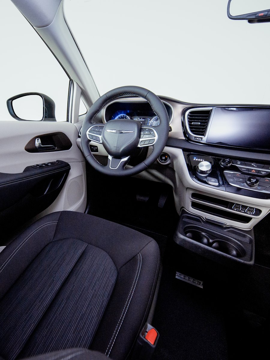 The driver and front passenger seats of a Chrysler Pacifica, unmodified, with the standard dashboard and steering wheel.