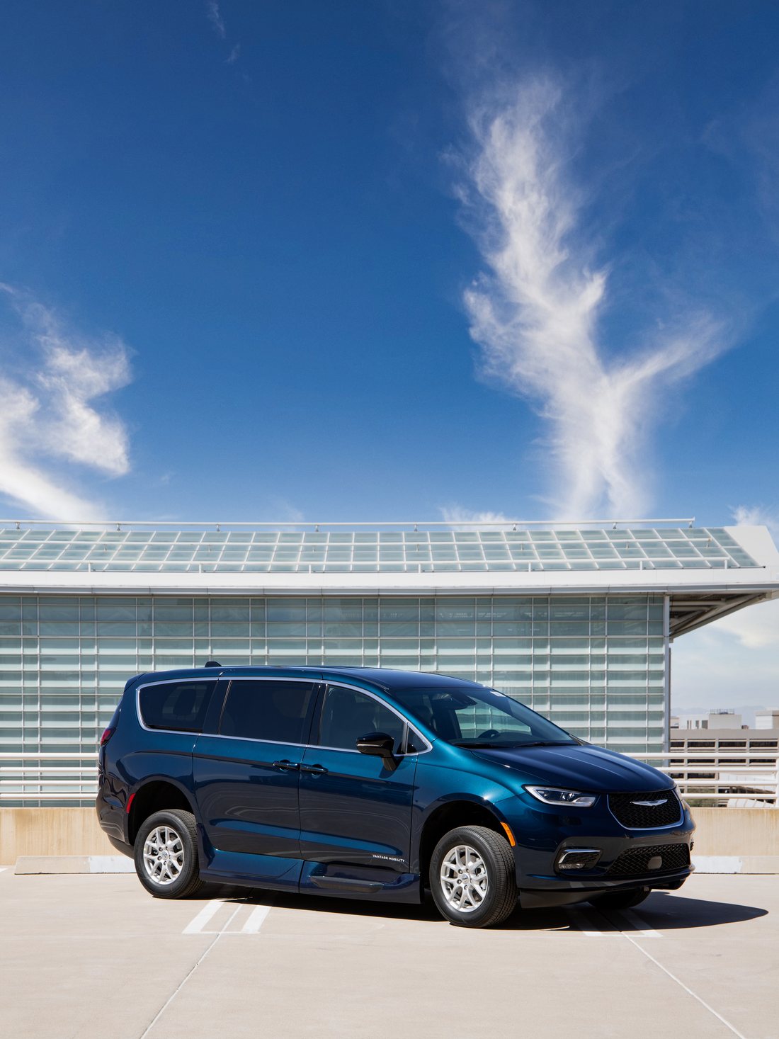 The same Pacifica with its doors closed, parked on a rooftop deck &mdash; from the outside it reads as an ordinary minivan.